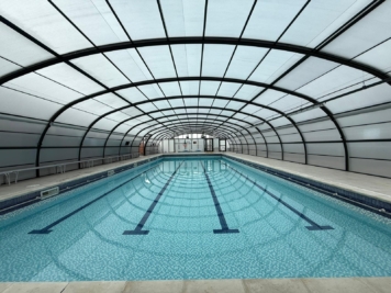 Solar control window film installed on indoor swimming pool enclosure, reducing glare and heat while maintaining natural light in commercial leisure facility