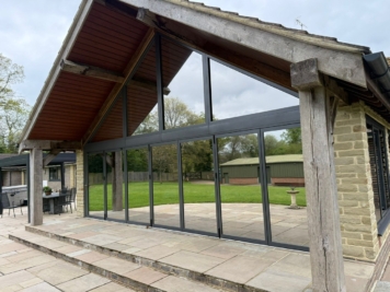 Large bifold patio doors with solar control window film installed, helping to reduce heat build up and glare while preserving clear outdoor views in a modern home extension