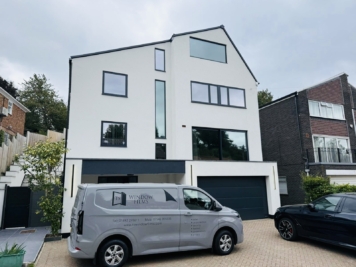 Modern white residential property with large glazed windows fitted with solar control window film, installed by TS Window Films to improve privacy, glare reduction and energy efficiency