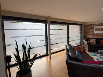 Interior view of sliding patio doors with frosted privacy window film, allowing daylight in while obscuring external visibility for added home privacy.