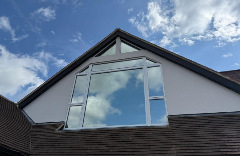 Large gable end window fitted with solar control window film, enhancing energy efficiency and reducing heat build up in modern home.
