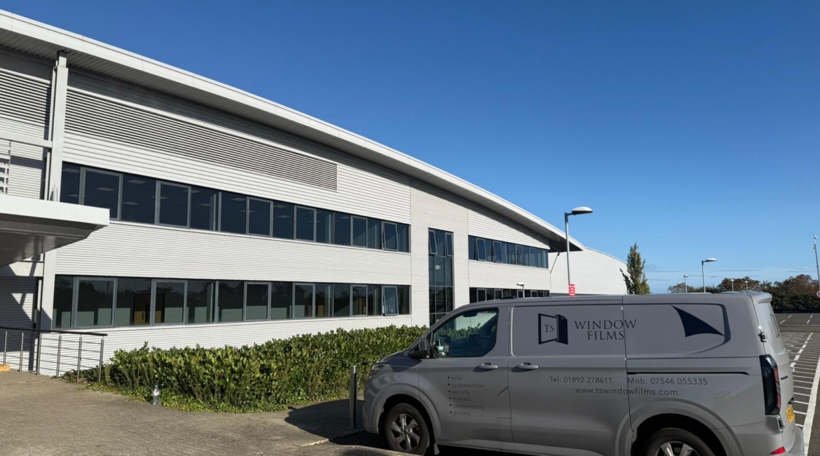 TS Window Films branded van parked outside large commercial building, providing professional solar control and security window film installation services.