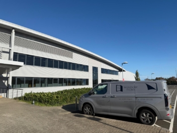 TS Window Films branded van parked outside large commercial building, providing professional solar control and security window film installation services.