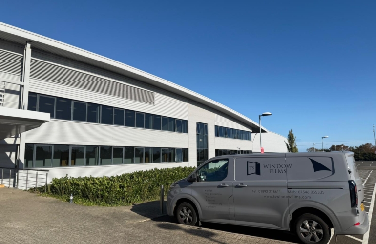 TS Window Films branded van parked outside large commercial building, providing professional solar control and security window film installation services.