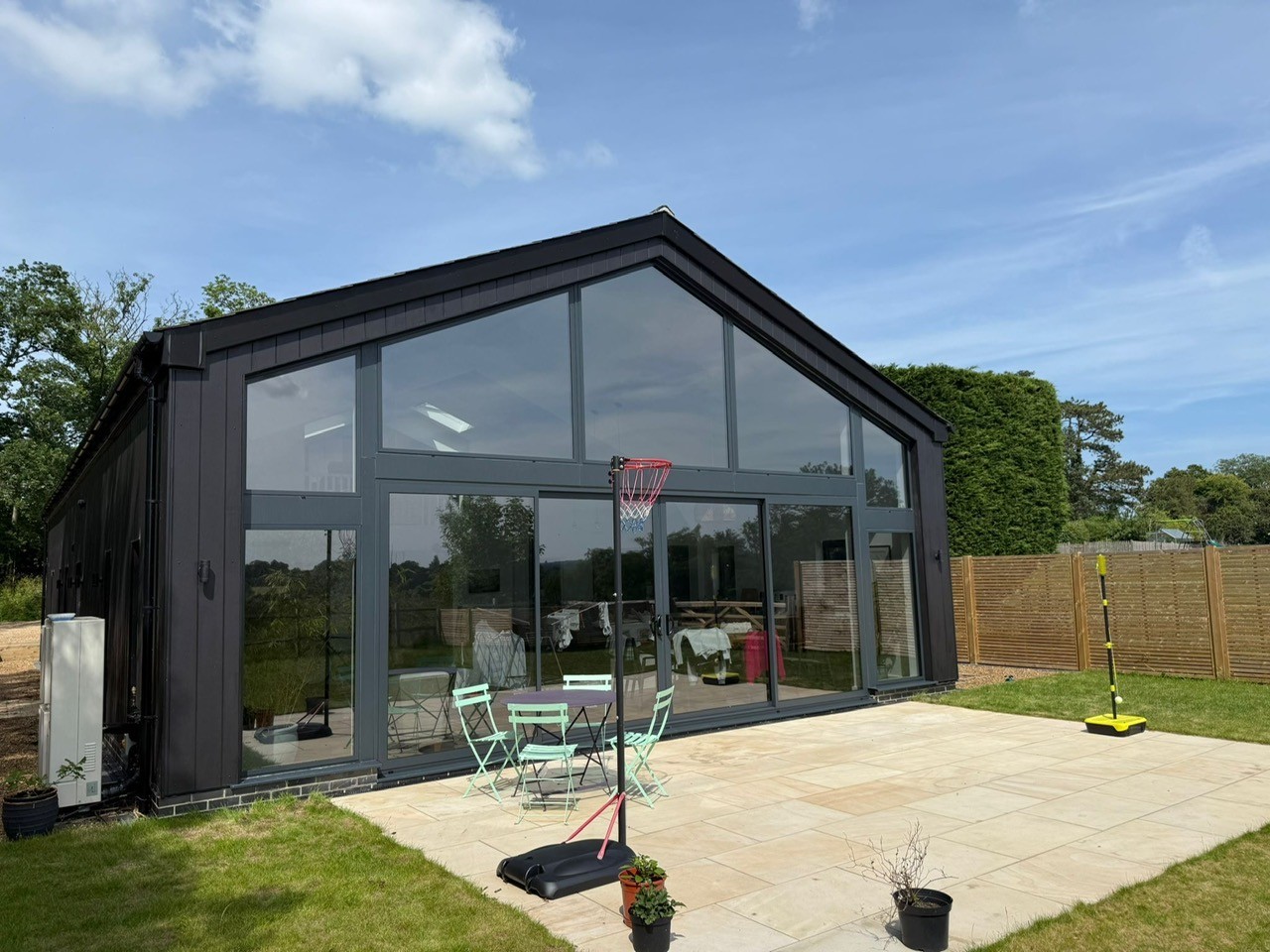Large residential garden room with floor to ceiling glazing fitted with solar control window film, improving heat reduction and glare control for modern home extension